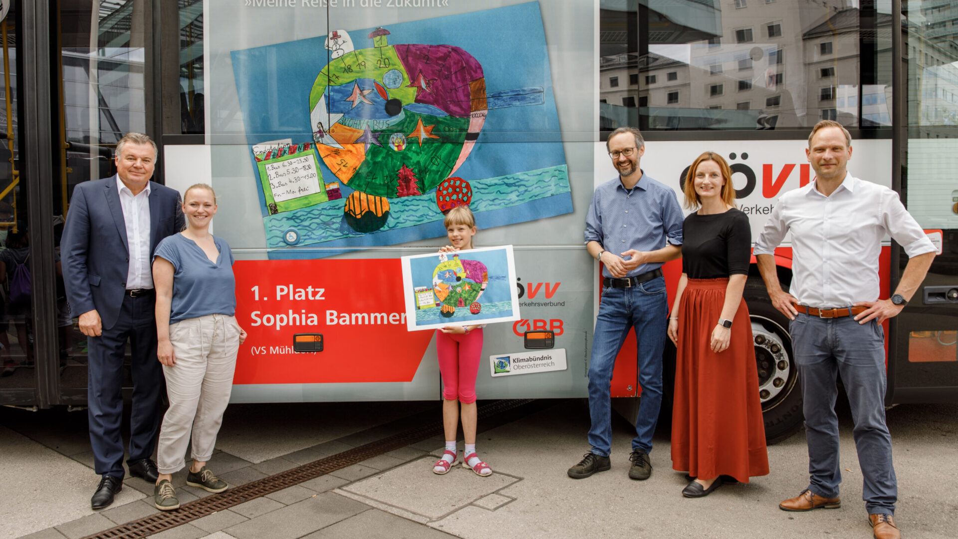 Präsentation des Siegerbildes des Öffi-Malwettbewerbs Sophia Bammer mit 5 Erwachsenen