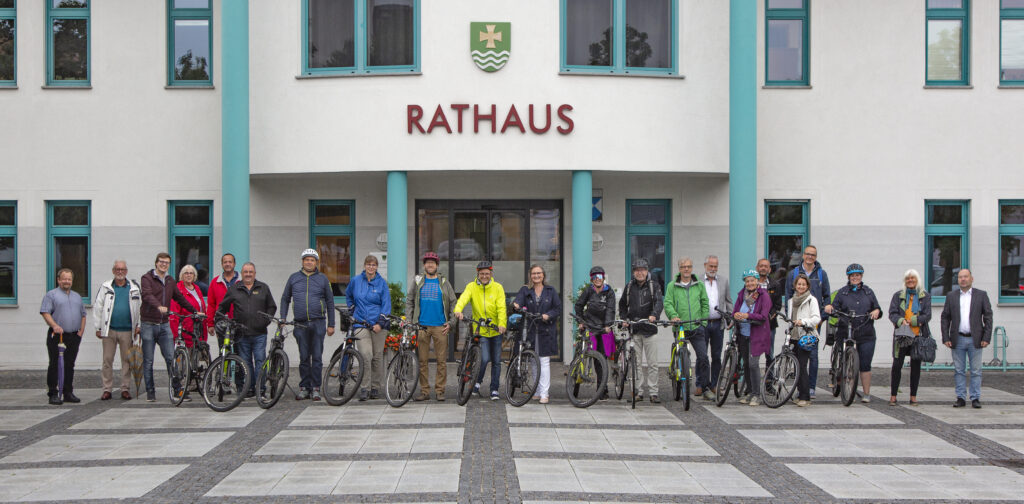 Eine Gruppe von Personen posiert mit Fahrräder vor dem Rathaus der Gemeinde Seewalchen am Attersee