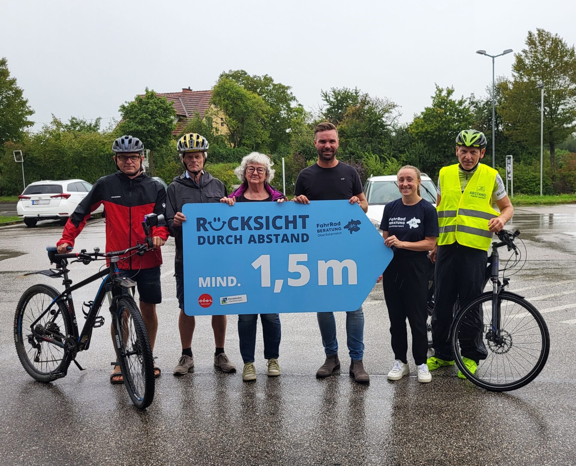 6 Personen präsentieren Tafel "Rücksicht mit Abstand"