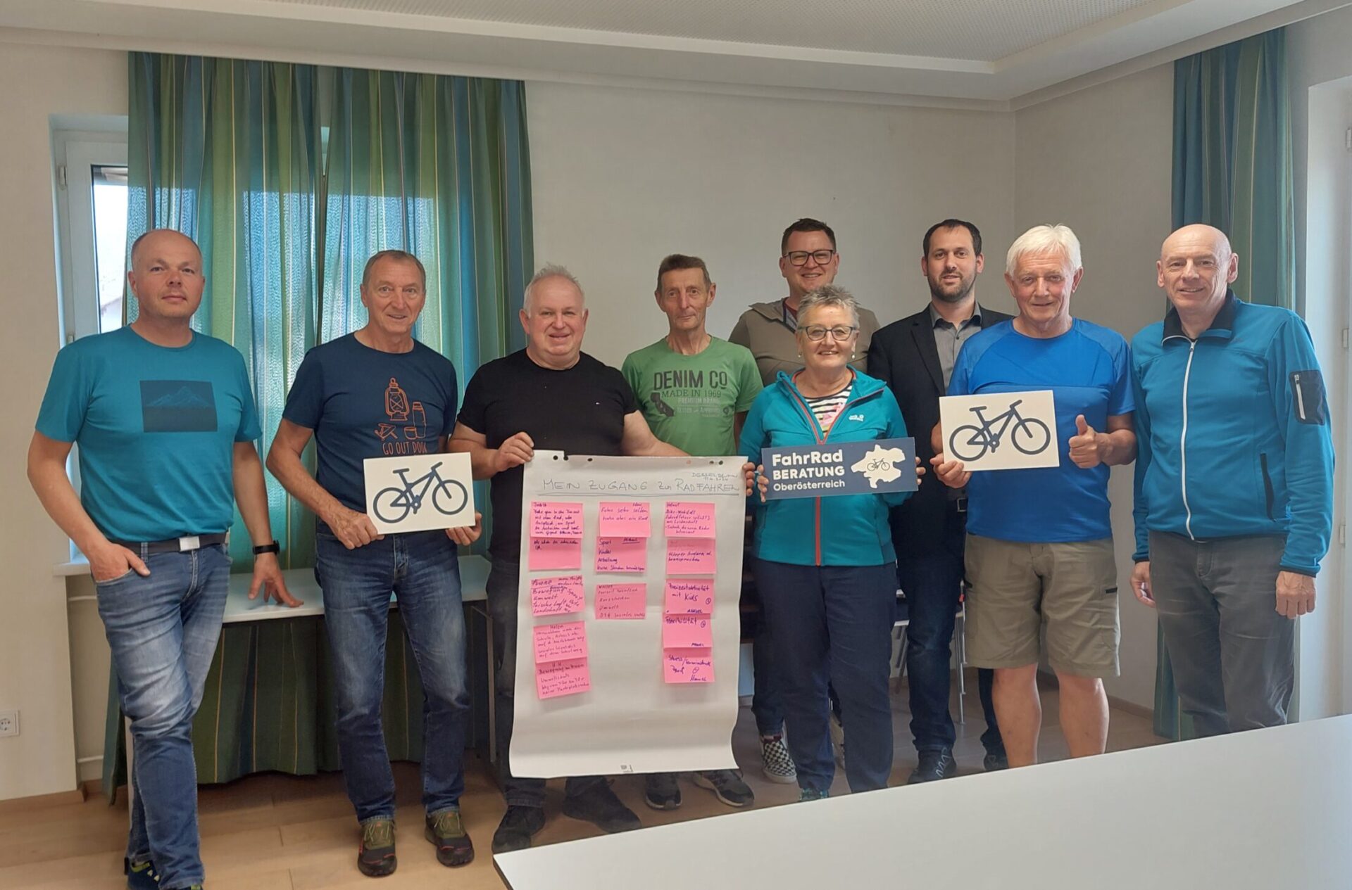 neun Personen halten Schilder von der Fahrradberatung und ein Flipchart
