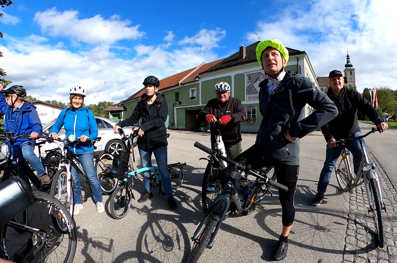 Gruppe von Radfahrenden in ländlichem Ortskern