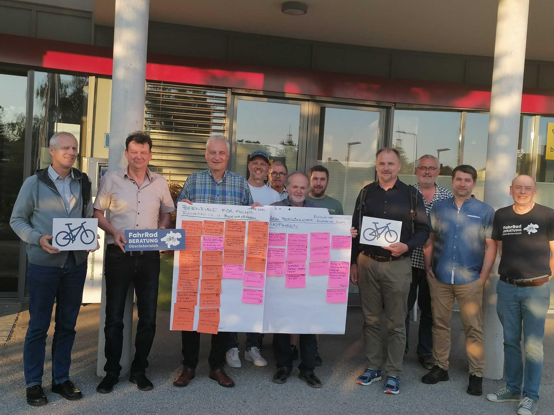 mehrere Männer halten verschieden Schilder zum Thema "Radfahren"