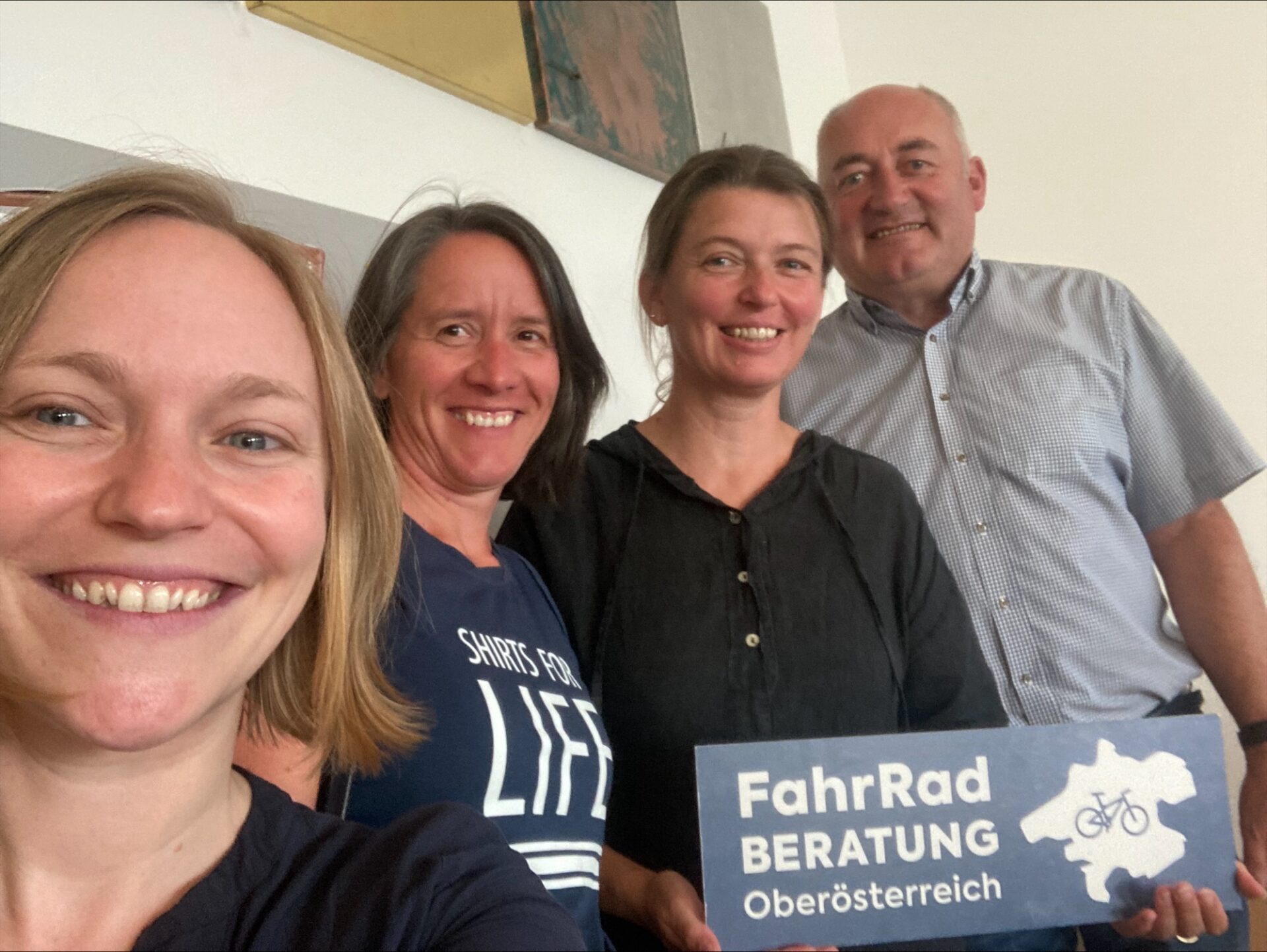 Gruppenfoto von vier Personen, eine Person hält ein Schild von der "Fahrradberatung" in der Hand