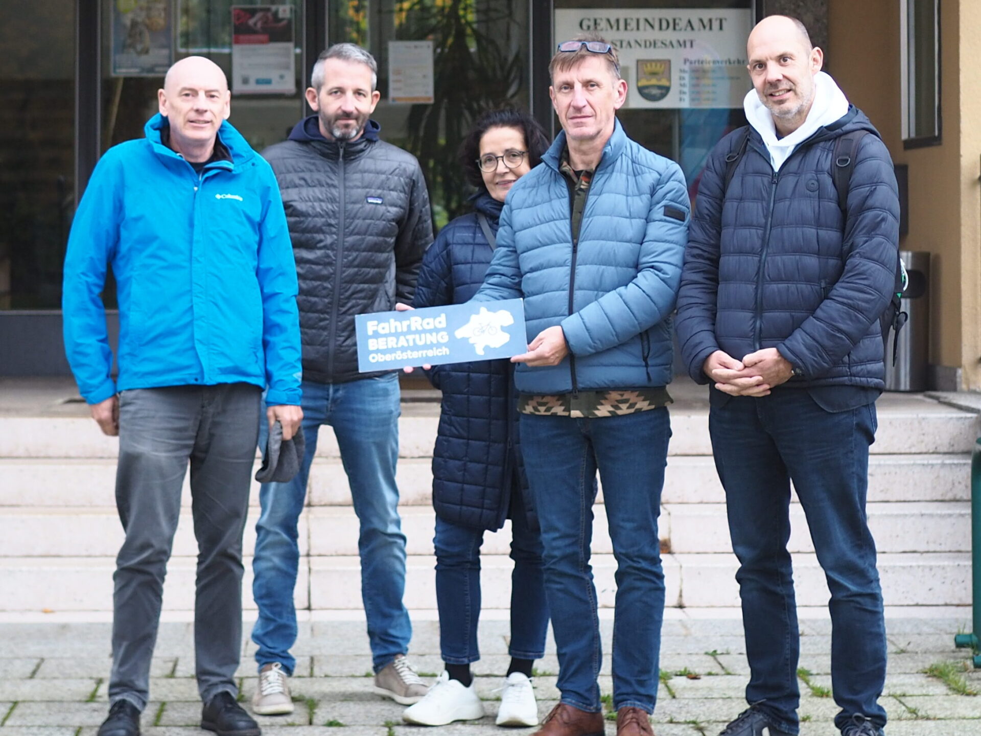Workshopteilnehmer vor Gemeindeamt Attersee mit Schild der FahrRad Beratung Oberösterreich