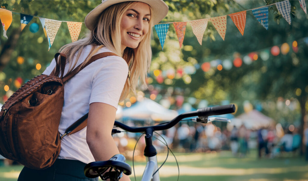 Frau auf Rad vor einem Gartenfest