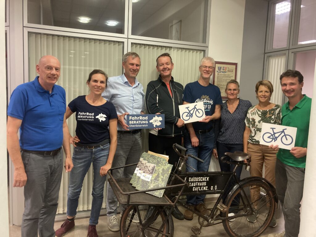 Teilnehmer:innen des Workshops stehen vor altem Waffenrad im Gemeindeamt