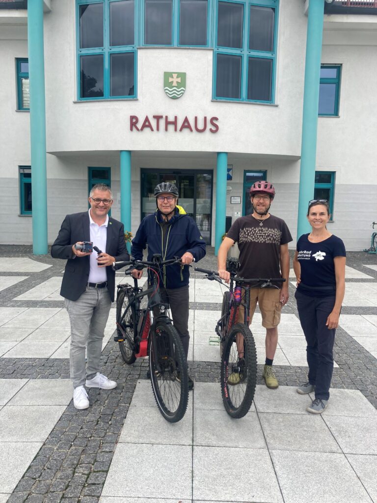 Bürgermeister Gerald Egger und Radteam vor Rathaus Seewalchen mit Abstands-Messgerät