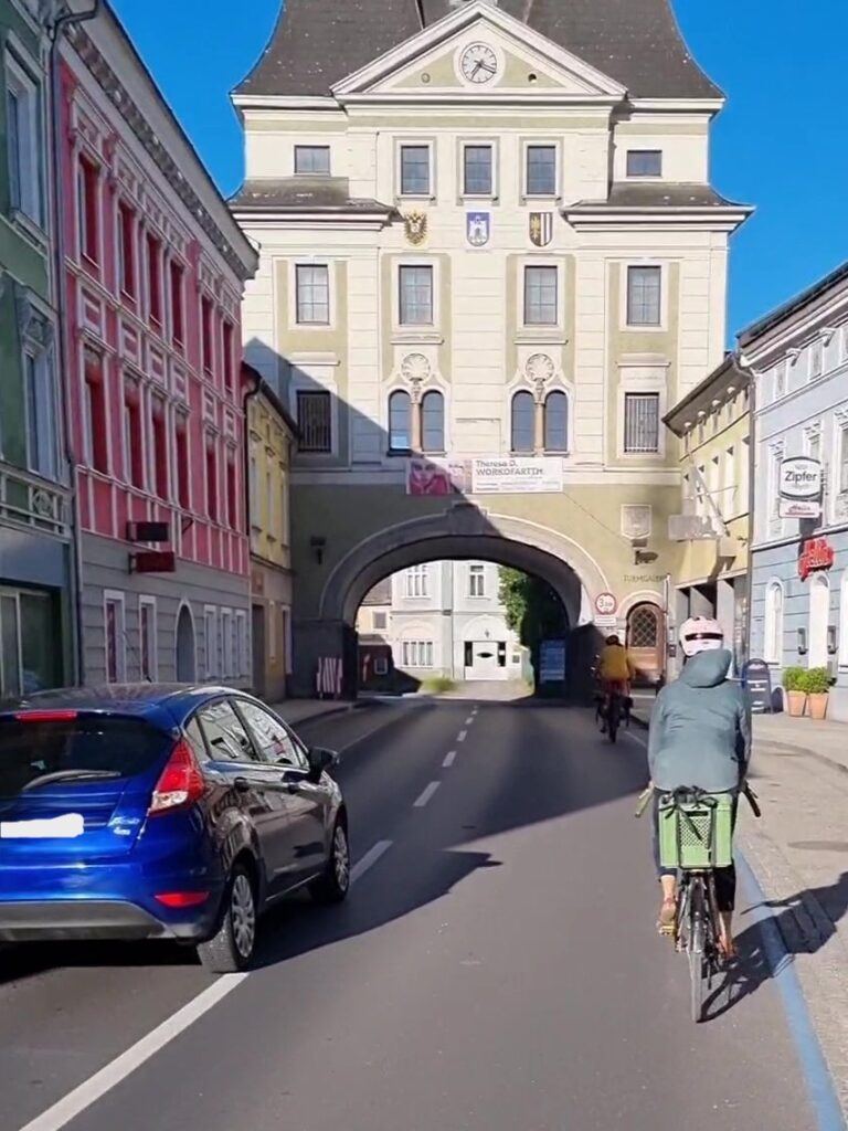 Überholvorgang Auto überholt Fahrrad mit ausreichendem Abstand auf vor Stadtturm